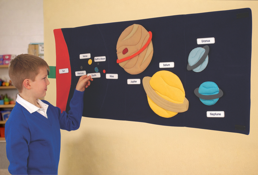 boy arranging the planets on an educational solar system mat